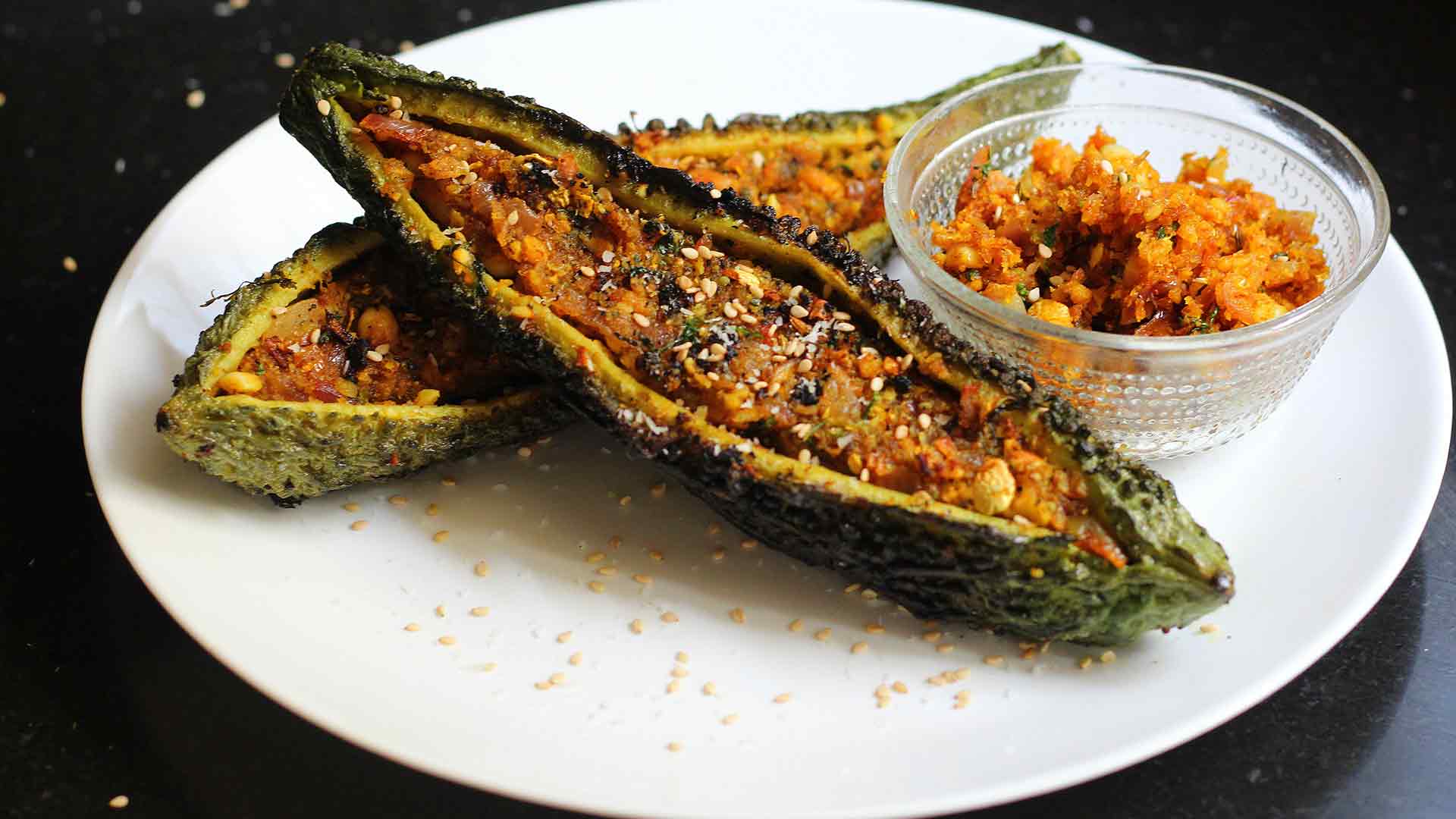 विधि - How to make Stuffed Karela करेलों को धोकर पानी सुखा लीजिए। करेले चाकू से खुरचते हुए छील लीजिए। इसके बाद, प्रत्येक करेले को बीच में से लंबाई में इस प्रकार काटे कि करेले नीचे और ऊपर की ओर से जुड़े रहे। करेलों में से बीज और उसका पल्प बाहर निकाल कर अलग रख लीजिये।